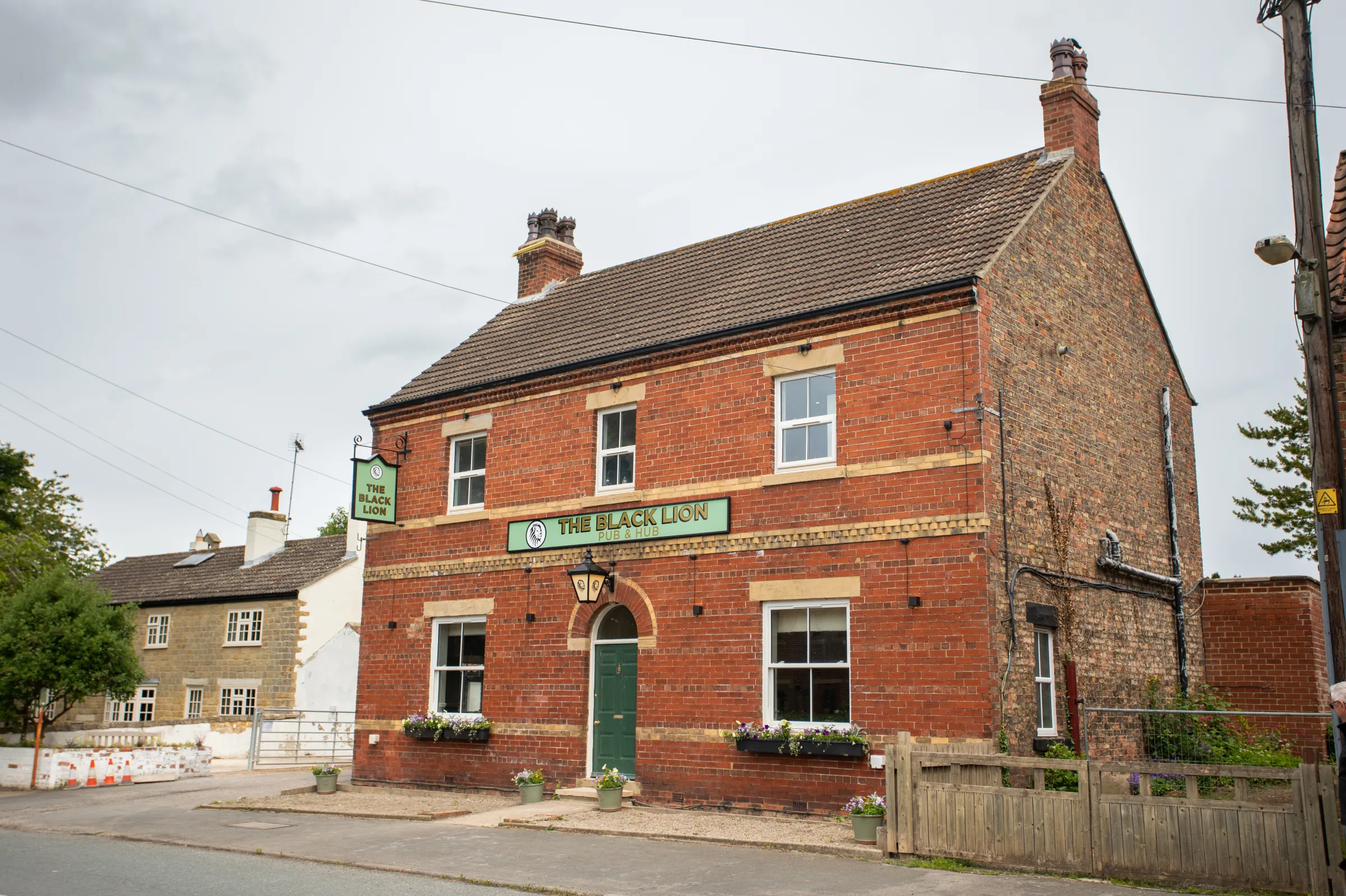 The Black Lion Pub & Hub brick frontage and hanging sign