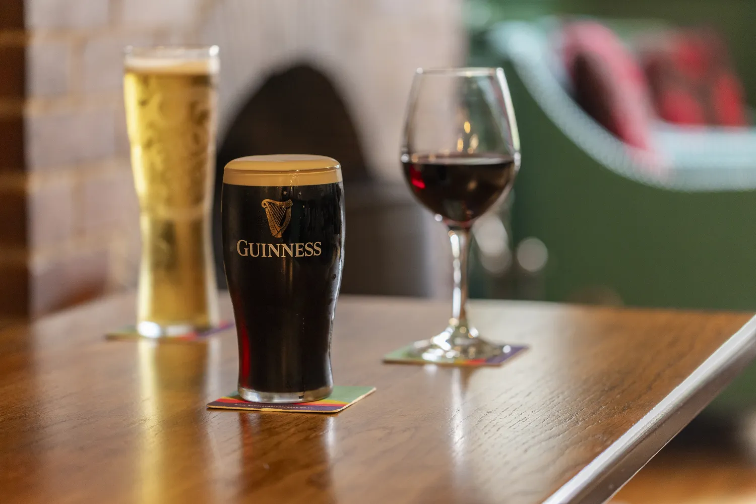 Lager, Guinness and red wine served at a pub table
