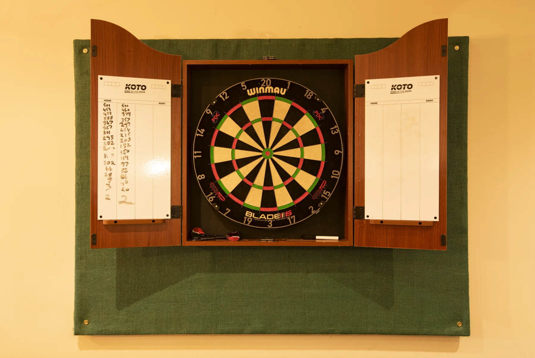 Winmau dartboard in a wooden cabinet with scoreboards at The Black Lion