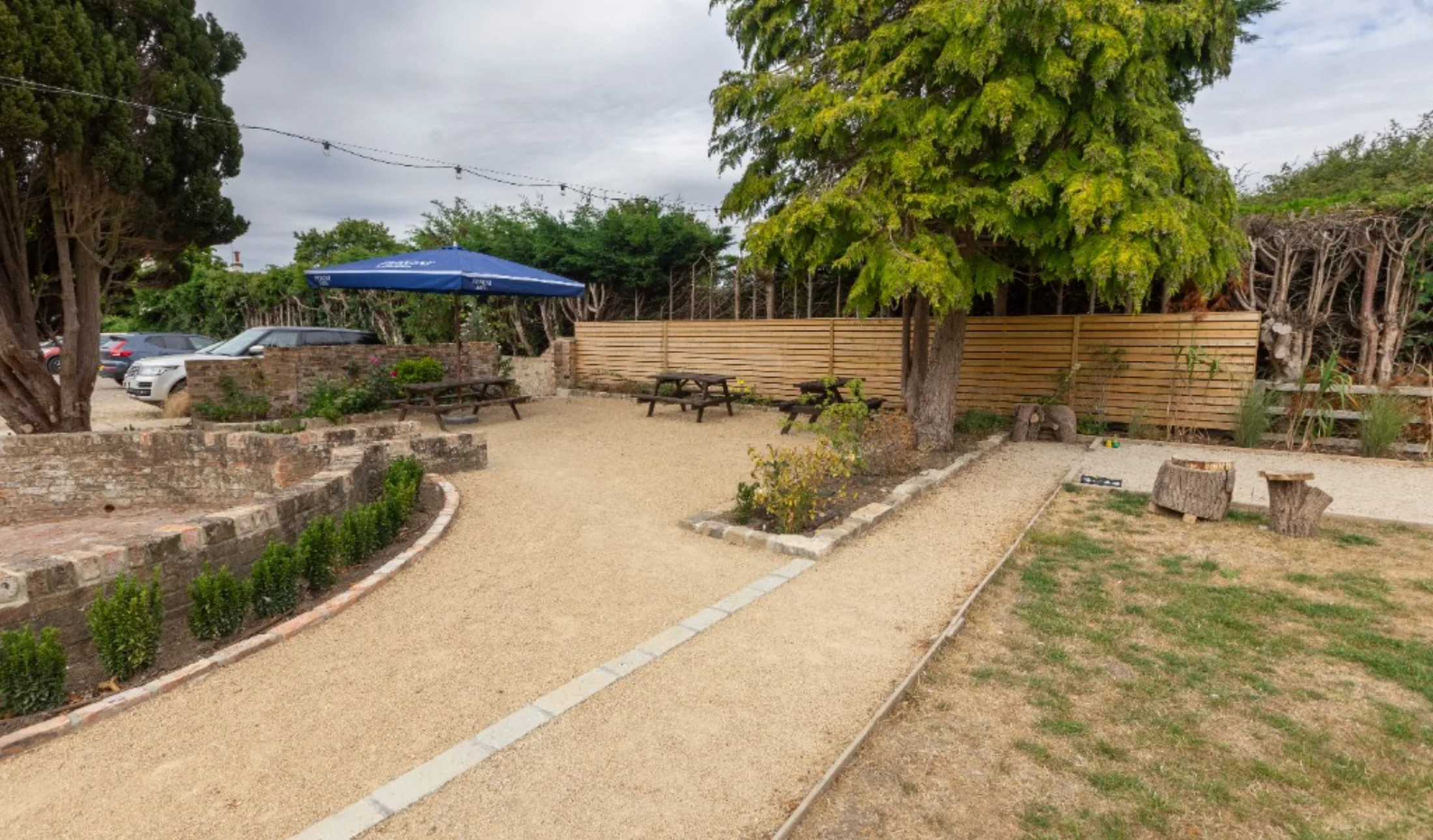 The gravel courtyard, brick wall and festoon lights in the beer garden