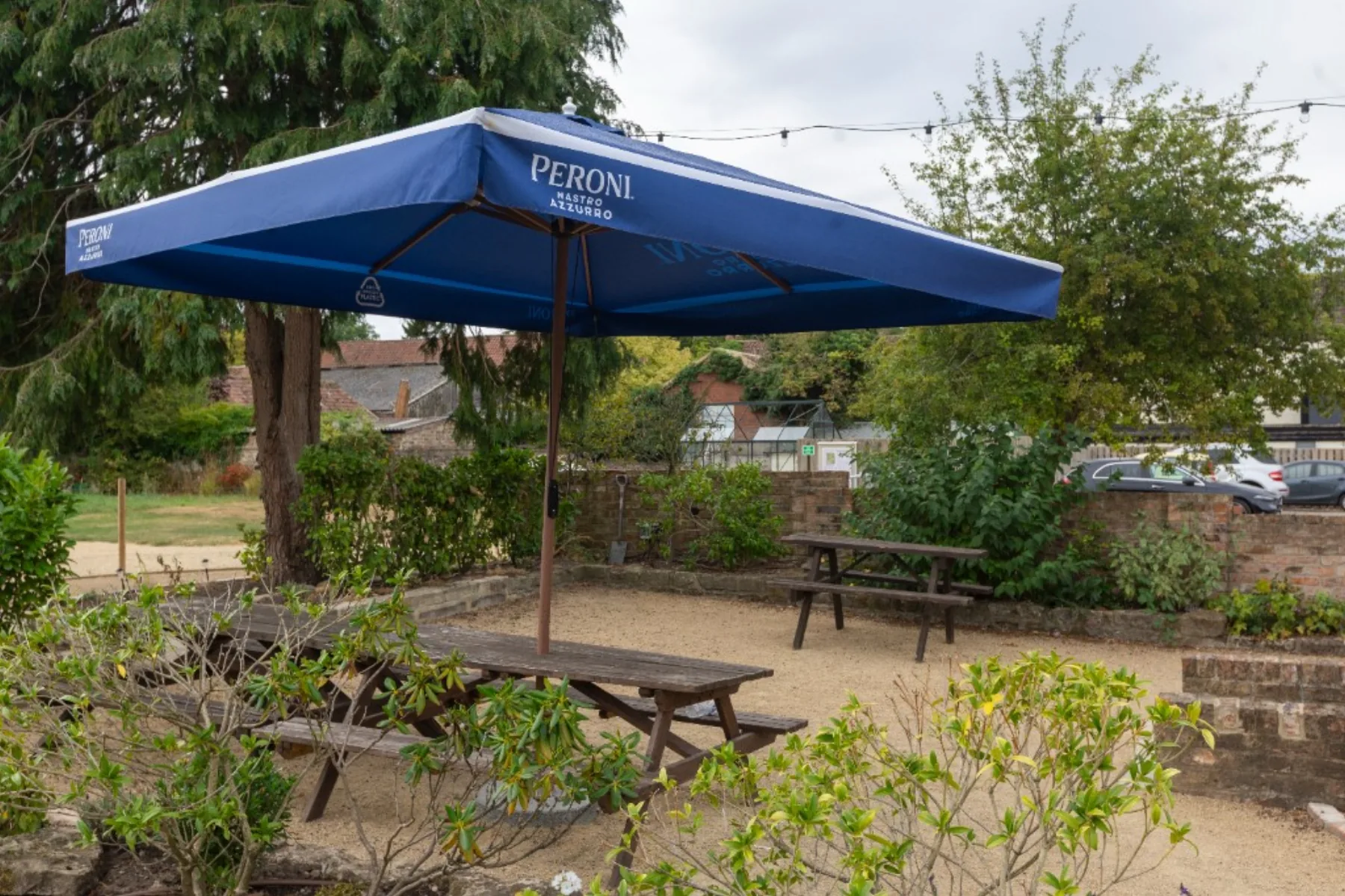 A Peroni umbrella shading a picnic table in the beer garden