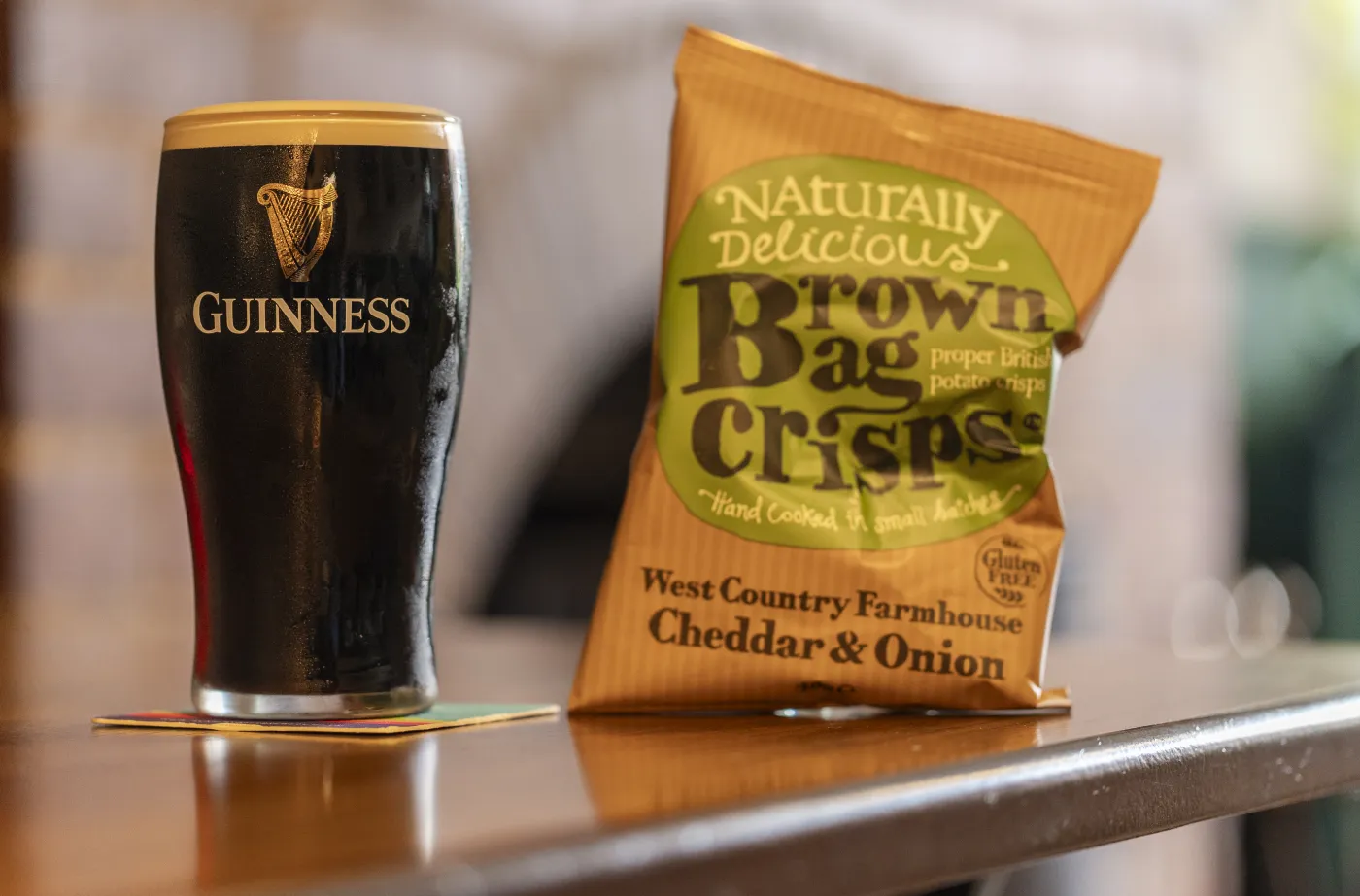 A pint of Guinness with a packet of crisps