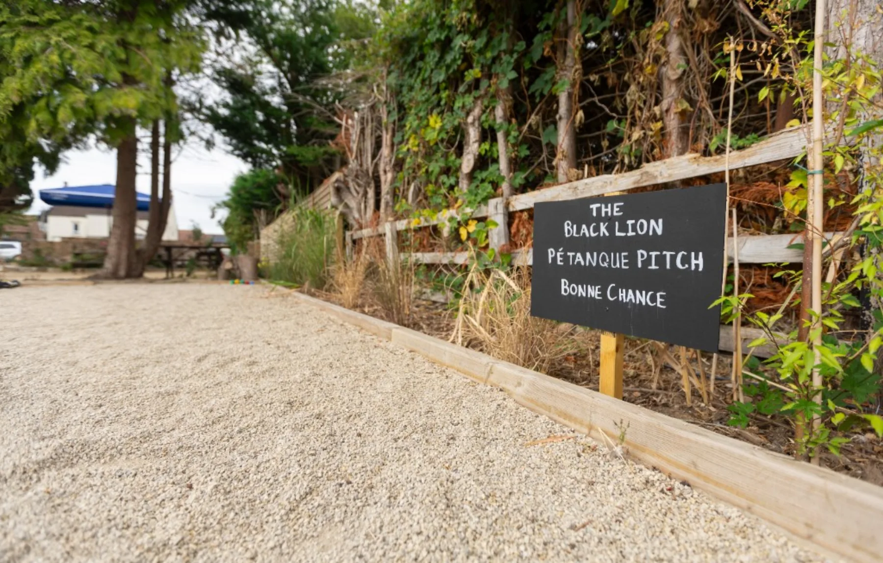 Looking down the pétanque pitch toward the trees and garden seating